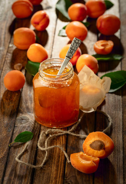 istock Apricot jam and fresh fruit on an old wooden table. 2153332461