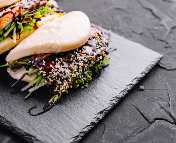 Asian fusion gourmet bao bun on slate background