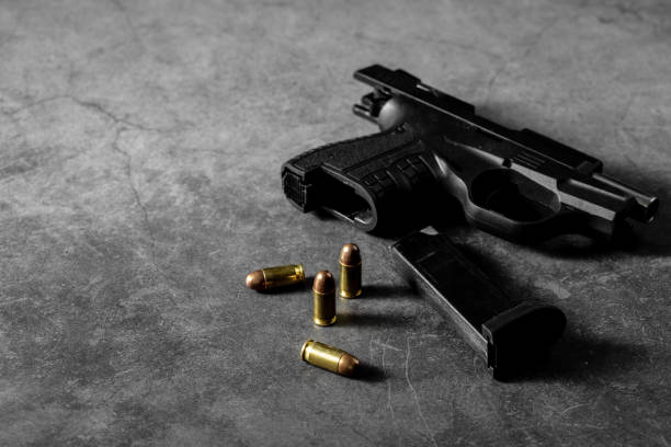 istock 9 mm gun and ammunition on black background 2153336817