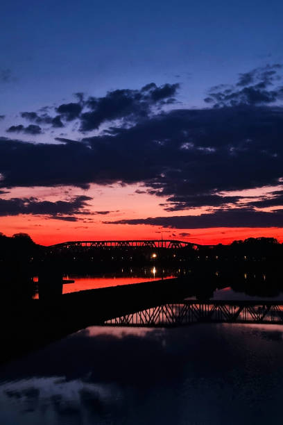 istock Stunning Sunset Silhouette Over Bridge and Reflective Water 2153336825