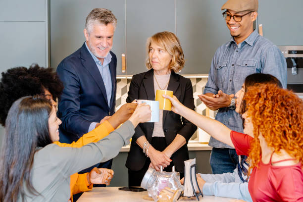 istock Diverse group of colleagues sharing coffee break in a modern office kitchen. 2153337037