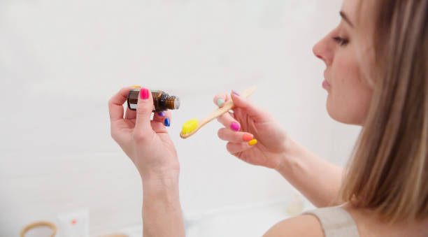 istock woman in bathroom brushing her teeth using essential oils.  Aroma therapy 2153337197