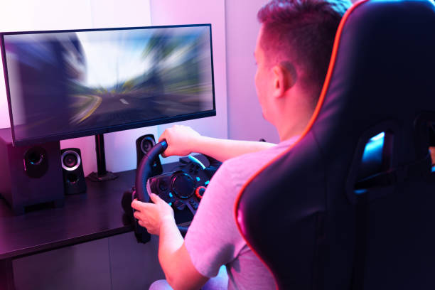 istock A man is playing a video game with a steering wheel 2153338686