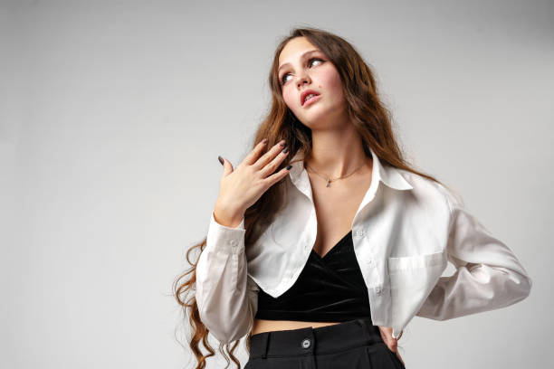 Fashion Model Posing in Stylish Black and White Attire in Studio Setting