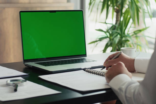 istock Businessman Using Laptop Computer With A Chroma Key Green Screen In The Office 2153340291