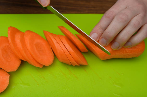 Cutting fresh carrots into slices close-up