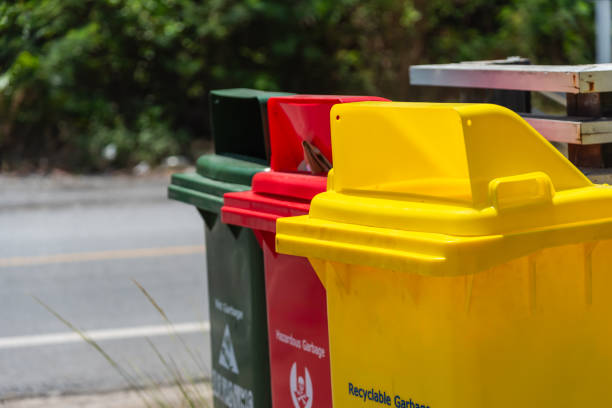 Garbage bins for sorting waste materials beside the walk way. Recycling bin stands outdoor.