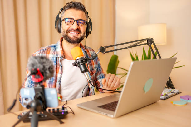istock mature man recording a podcast in a home studio 2153346324