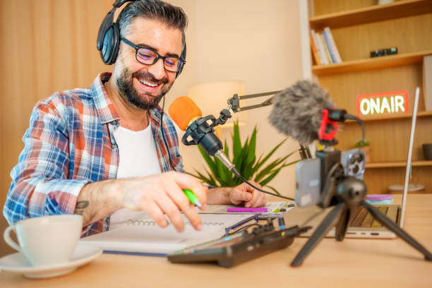istock mature man recording a podcast in a home studio 2153346416