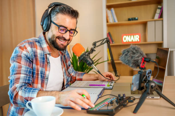 istock mature man recording a podcast in a home studio 2153346876