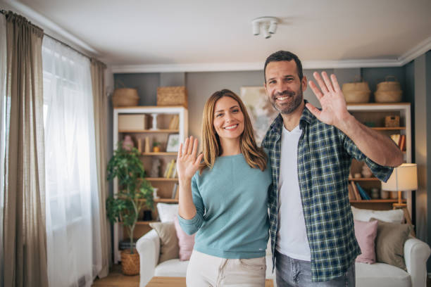 istock Cheerful couple waving while looking at camera and smiling 2153348552