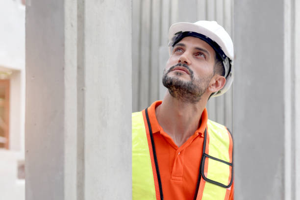 istock Happy worker engineer with safety vest and helmet inspecting working area at construction site. Architect working and checking house structure at building site workplace. Labor construction. 2153350624