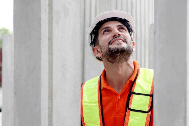 istock Happy worker engineer with safety vest and helmet inspecting working area at construction site. Architect working and checking house structure at building site workplace. Labor construction. 2153350850