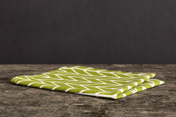 istock top view with green kitchen napkin isolated on table background. Folded cloth for mockup with copy space, Flat lay. Minimal style 2153352008