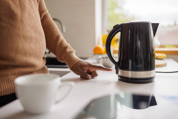 istock Young man using an electric kettle to make tea at home 2153356519