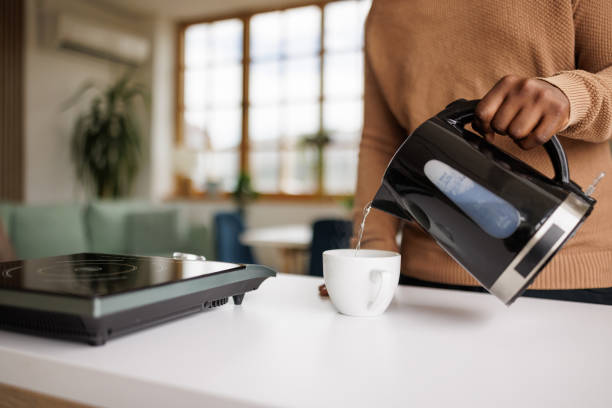istock Young man using an electric kettle to make tea at home 2153356576