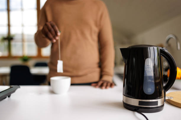 istock Young man using an electric kettle to make tea at home 2153356581