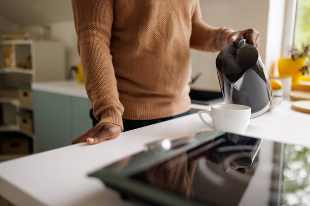 istock Young man using an electric kettle to make tea at home 2153356599