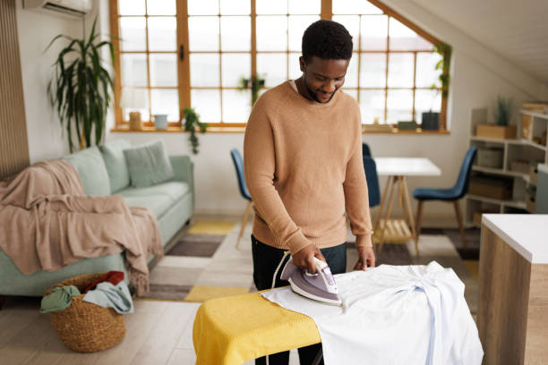 istock Young man ironing a shirt at home 2153356603