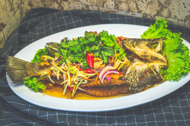 istock Deep Fried Seabass topeed With Mango Salad and served on a plate 2153358214
