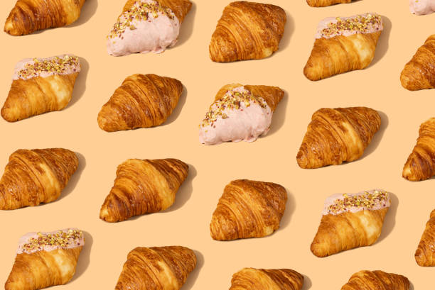 Fresh croissant against a pastel peach background