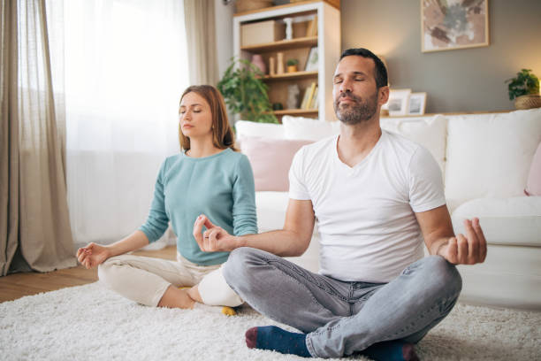 istock couple practicing yoga at home 2153358413