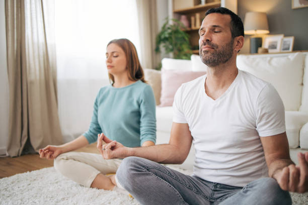 istock couple practicing yoga at home 2153358416