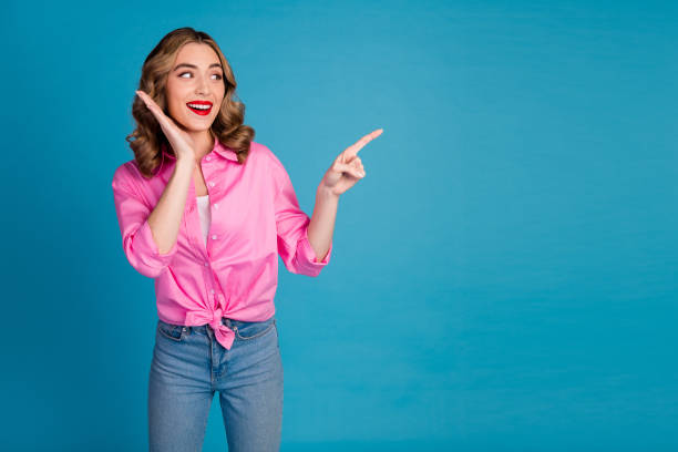 istock Photo portrait of lovely young lady impressed point empty space dressed stylish pink garment hairdo isolated on blue color background 2153358607