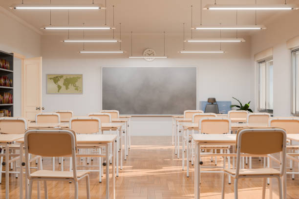 istock Empty classroom with desks and chairs facing a blackboard in a bright indoor setting 2153359054