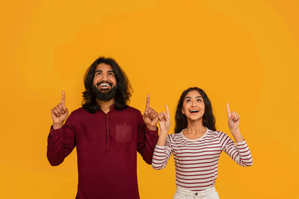 istock Excited young indian couple pointing up at copy space 2153361050