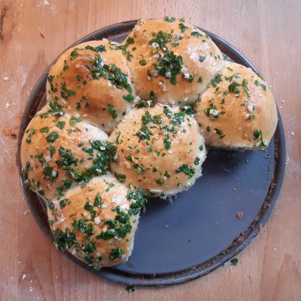 Sliced bread and herb butter with olive oil served on a tray for dinner