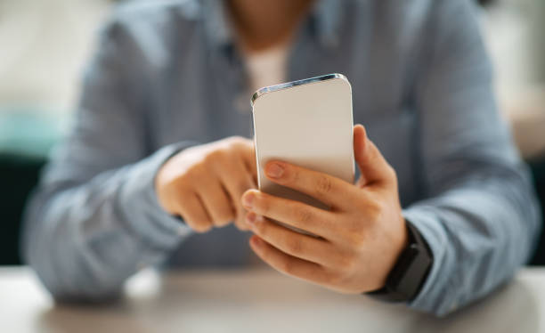 istock Close-up of a man's hands using a smartphone, focusing on the screen with a blurred background 2153361899