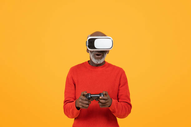 istock Amazed senior black man wearing a virtual reality headset and holding a game controller 2153363445
