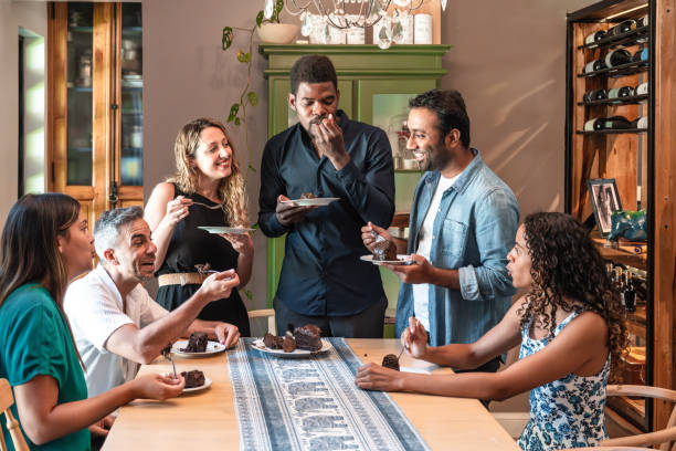 istock happy friends eating cake at dining table 2153364647