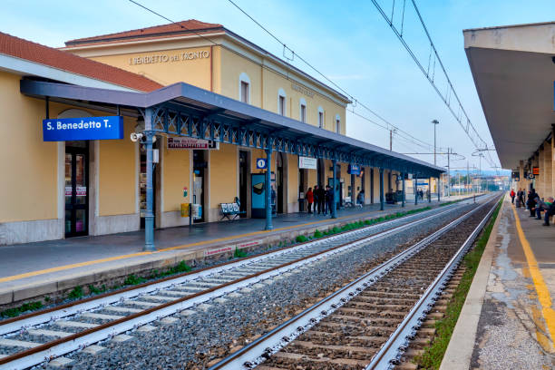 Generation Z, mixed race, woman waits for train in station, with mobile phone, Liguria