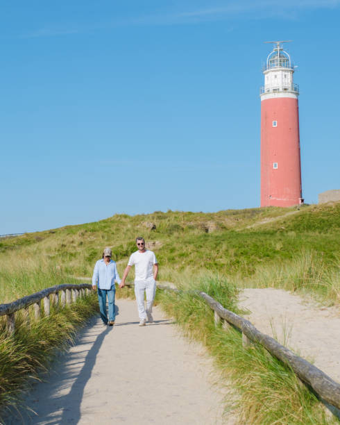 istock A couple strolling along a path by a stunning lighthouse in Texel, Netherlands, enjoying the scenic view and the peaceful surroundings 2153365022