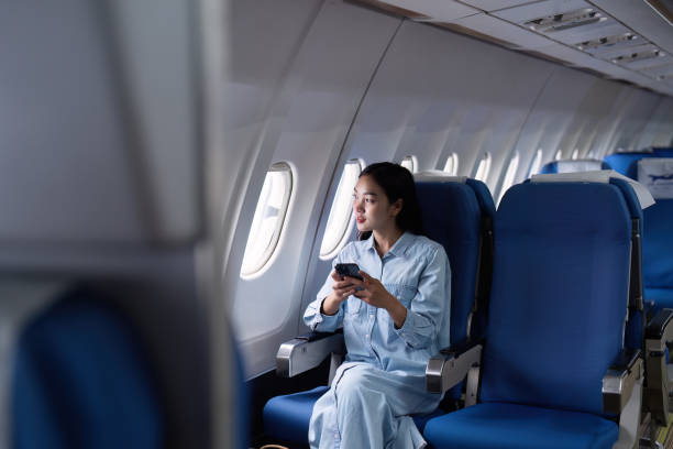 istock Asian people female person onboard, airplane window, using mobile while on the plane 2153365201