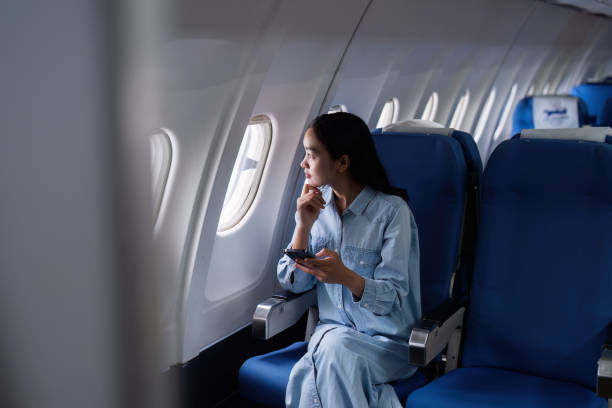 istock Asian people female person onboard, airplane window, using mobile while on the plane 2153365232