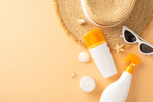 istock Top view of summer beach accessories arranged neatly on a beige surface, featuring sunscreen, a straw hat, sunglasses, and seashells 2153365272