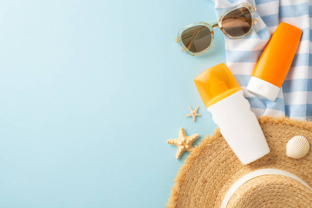 istock Top-view shot featuring SPF skincare bottles, sunhat, sunglasses, and beach essentials on a pastel blue backdrop. Protect your skin from UV rays while enjoying the sun. Ideal for skincare promotions 2153365290