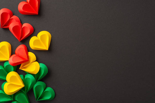 istock Emancipation remembrance: hearts in red, green, yellow on black, symbolizing Juneteenth's abolition of slavery. Top view leaves space for social text or advertising 2153365291