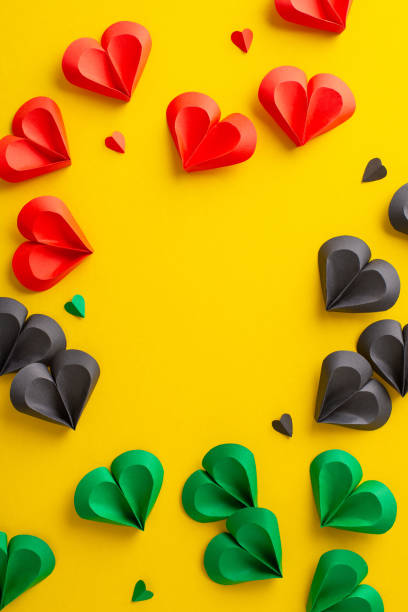 istock Symbolic Juneteenth top view vertical image: hearts in red, green, black on yellow, representing emancipation. Ready for social sharing or promotional use 2153365299