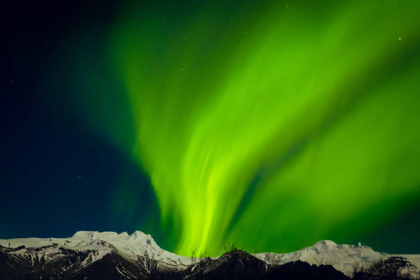 Generic copy space banner aurora borealis northern lights show over snowy white mountain peaks
