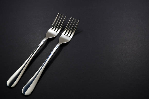 istock Forks pairing together isolated on black background close up view 2153368267