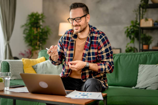 istock One men sitting and working from home, making a video call on a laptop, using technology concept 2153368274