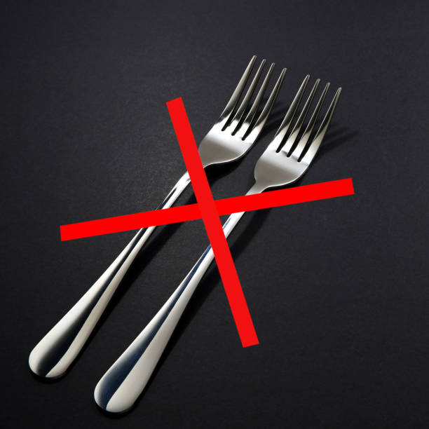 istock Silver fork set together placed on black background close up view with warning or alert sign 2153368328