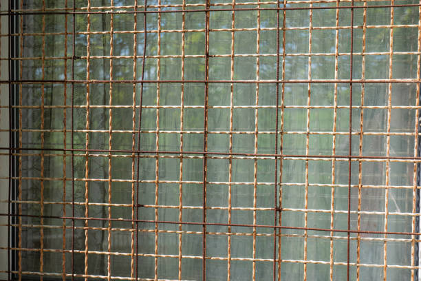 istock Close-up of an old rusty iron grille window on a rural house. 2153370084