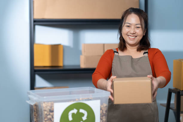 istock Woman Smiling While Packing Box with Eco-Friendly Materials 2153370768