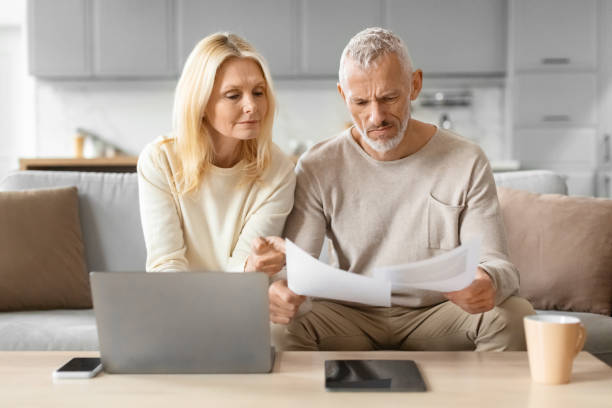 istock Focused couple looking at documents by a laptop 2153371041
