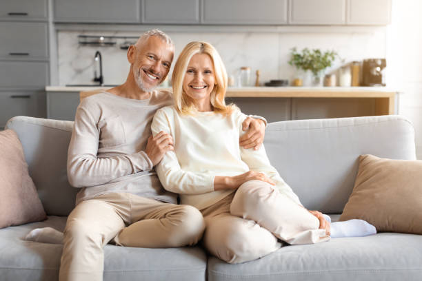 istock Happy loving senior spouses sitting on couch at home 2153371051